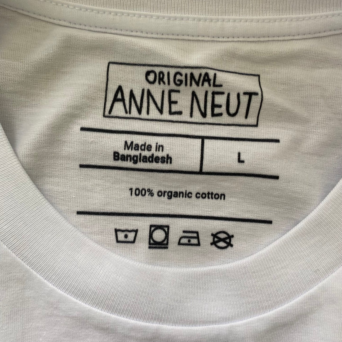 Shirt met borduurwerk van tekening van poepende hond door Anne Neuteboom cabaretier in Anne Neut Boetiek