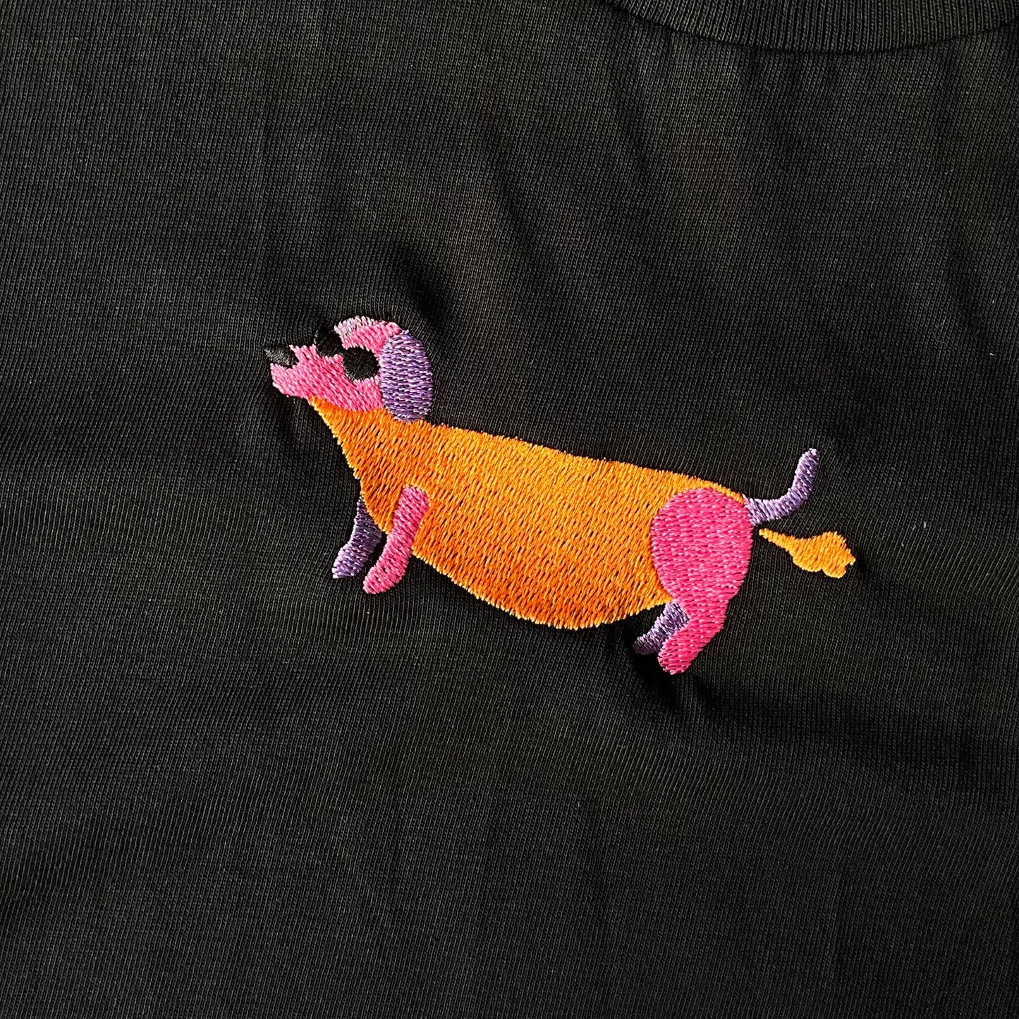 Shirt met borduurwerk van tekening van puffende teckel door Anne Neuteboom cabaretier in Anne Neut Boetiek