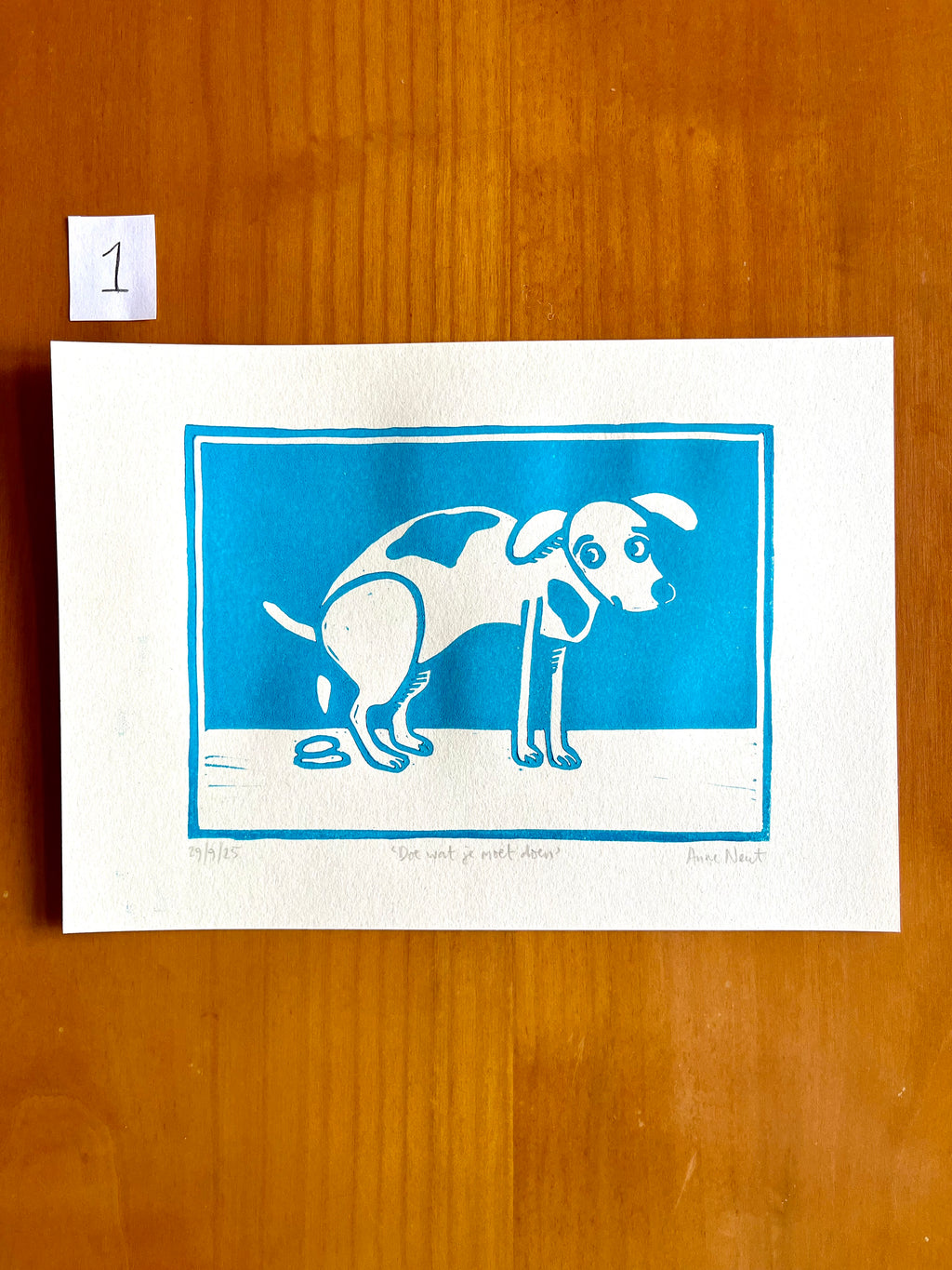 Linoprint van tekening van poepende hond door Anne Neuteboom cabaretier Anne Neut Boetiek