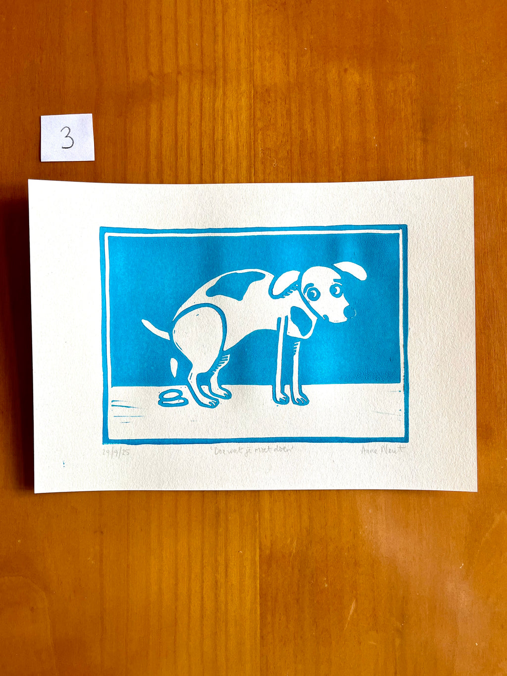 Linoprint van tekening van poepende hond door Anne Neuteboom cabaretier Anne Neut Boetiek