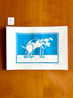 Linoprint van tekening van poepende hond door Anne Neuteboom cabaretier Anne Neut Boetiek
