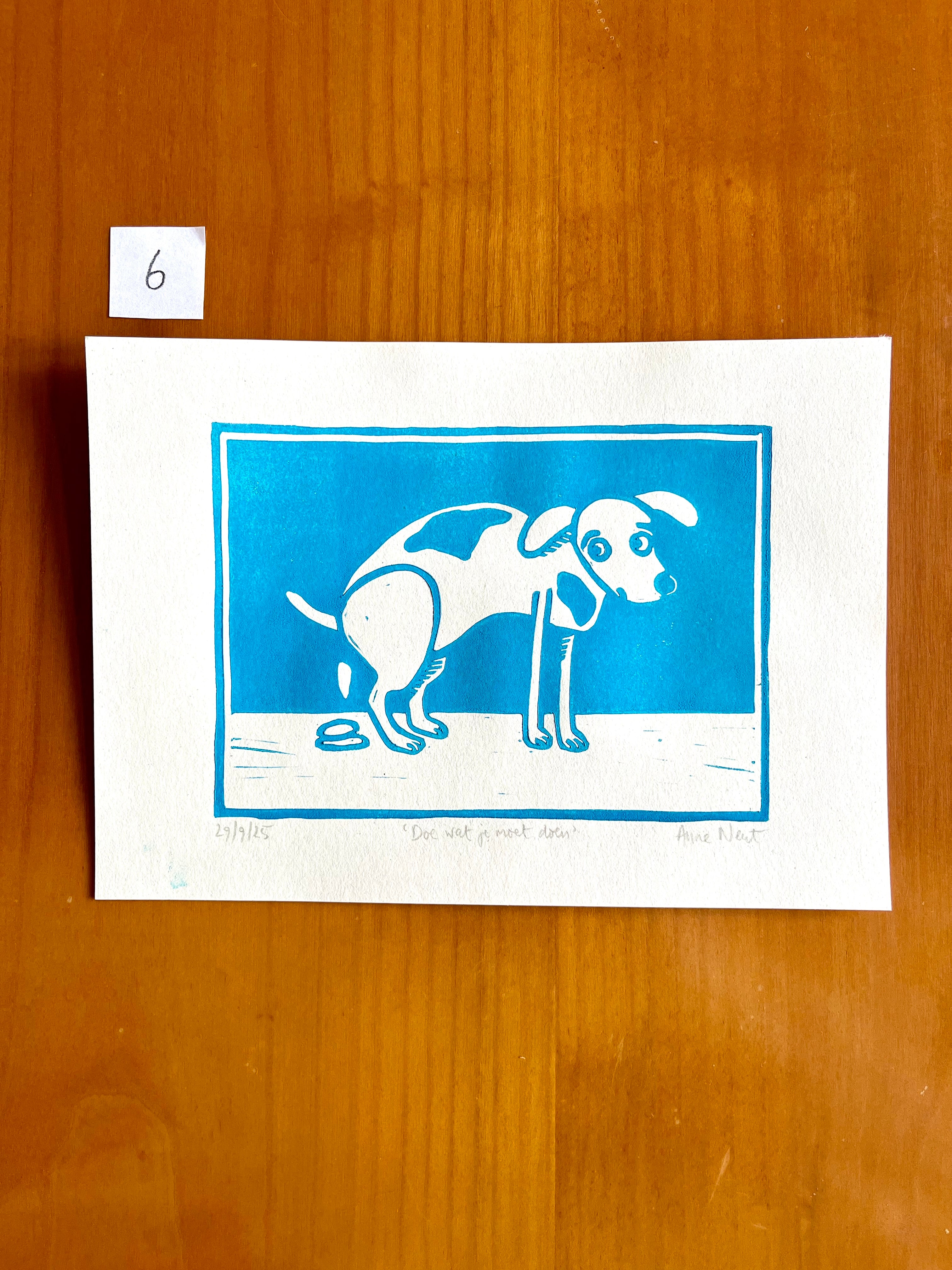 Linoprint van tekening van poepende hond door Anne Neuteboom cabaretier Anne Neut Boetiek