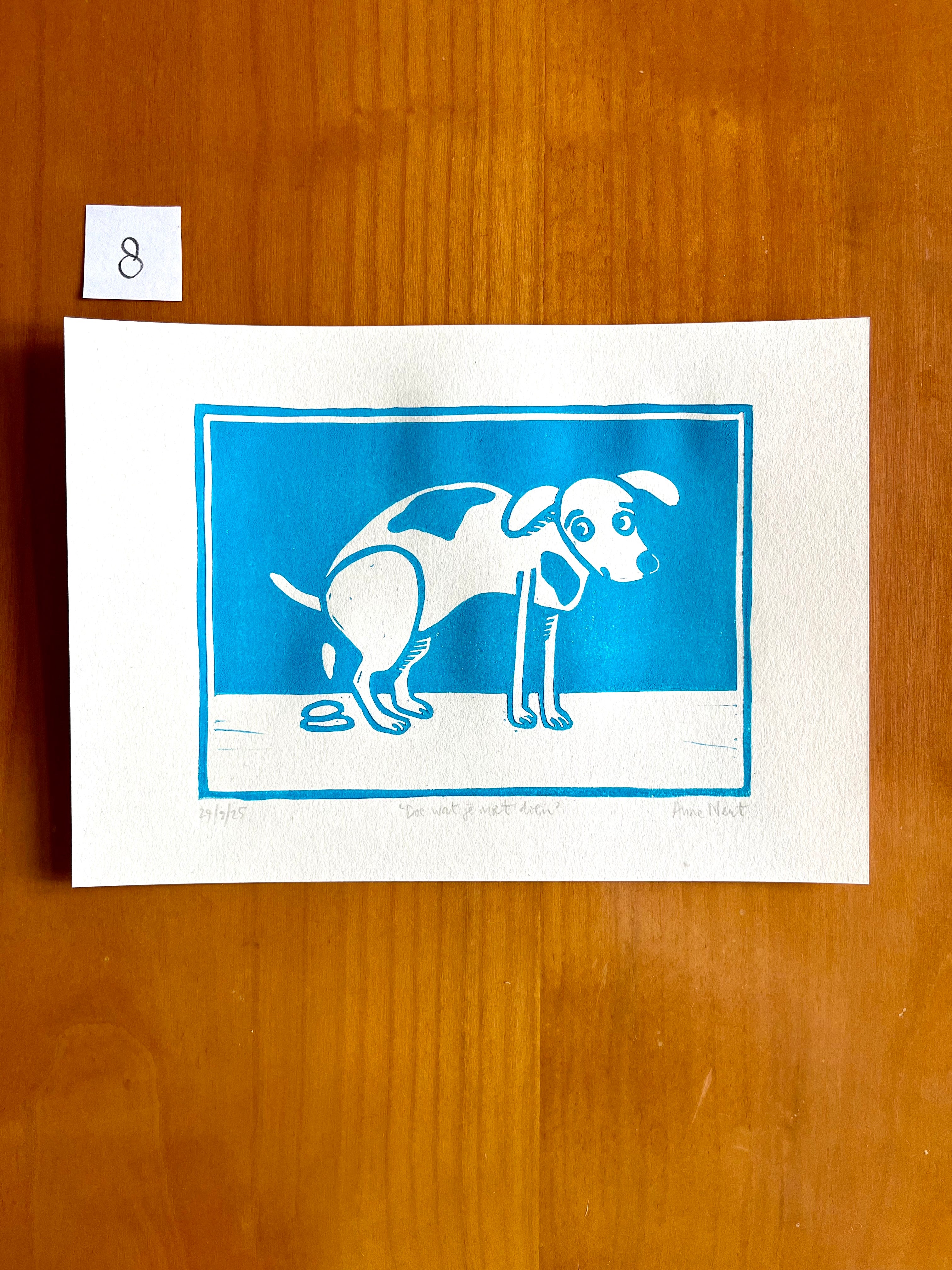 Linoprint van tekening van poepende hond door Anne Neuteboom cabaretier Anne Neut Boetiek