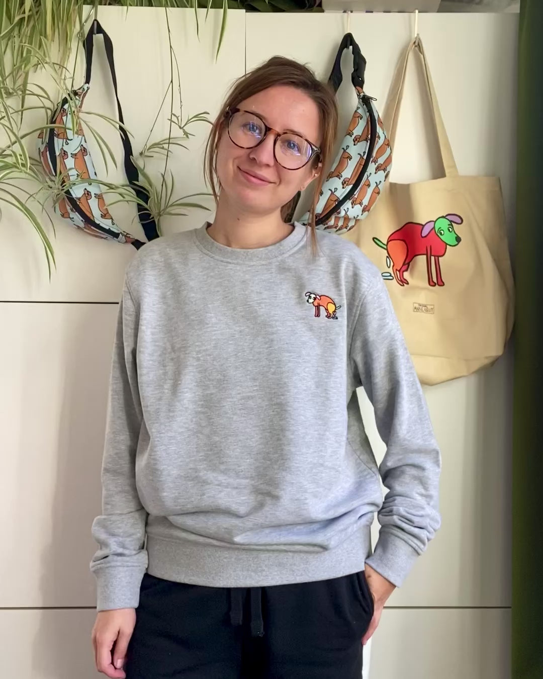 Sweater met borduurwerk van tekening van poepende hond door Anne Neuteboom cabaretier in Anne Neut Boetiek