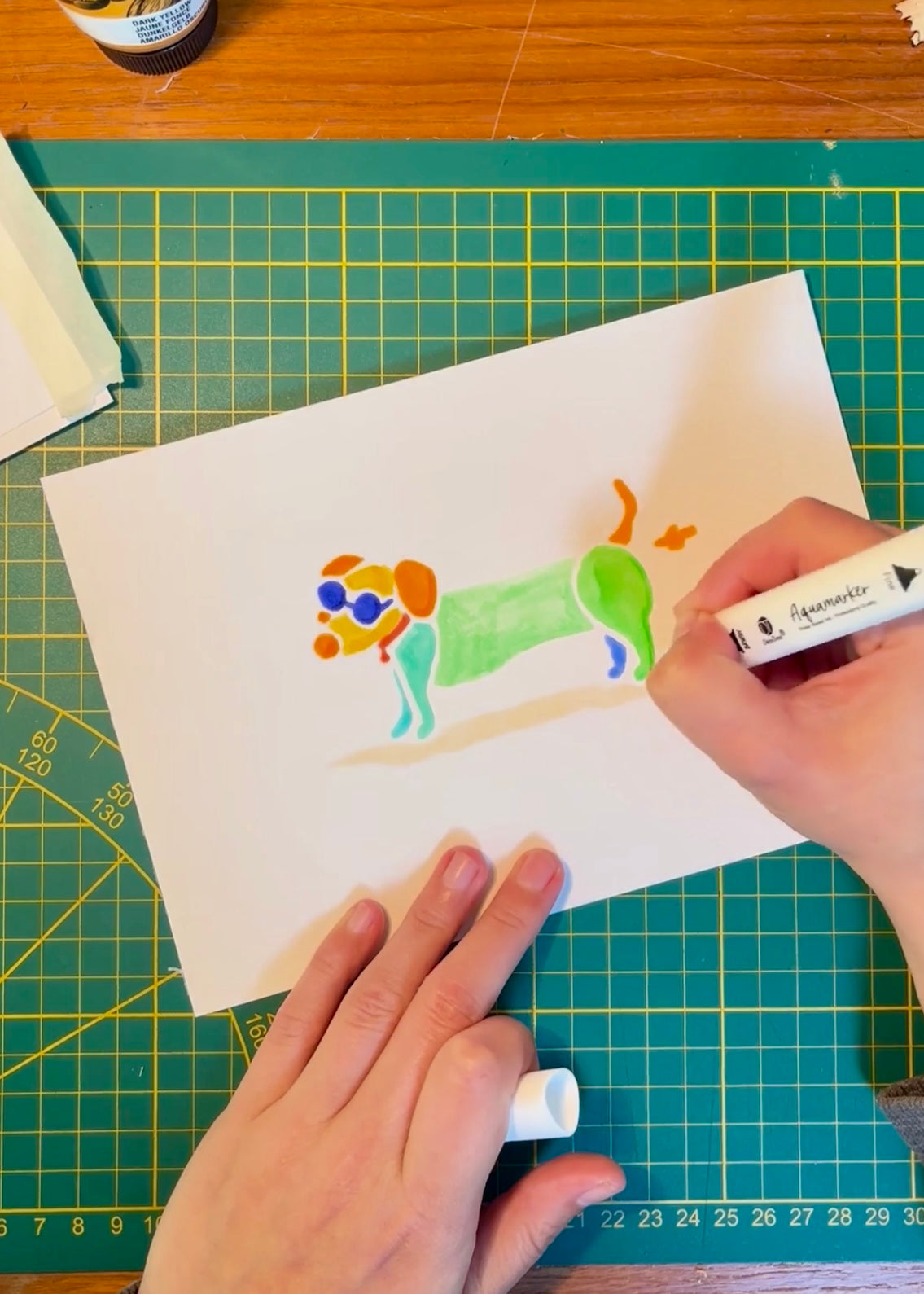 Tekening van teckel die een scheetje laat met aquarel markers op aquarel-papier door Anne Neuteboom cabaretier Anne Neut Boetiek