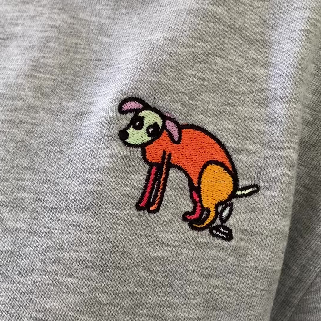 Sweater met borduurwerk van tekening van poepende hond door Anne Neuteboom in Anne Neut Boetiek