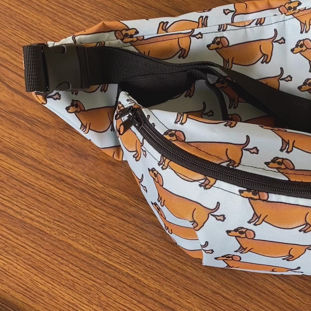 Fanny pack met tekening van puffende teckels door Anne Neuteboom cabaretier in Anne Neut Boetiek