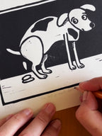 Blokdruk print van tekening van poepende hond door Anne Neuteboom cabaretier Anne Neut Boetiek
