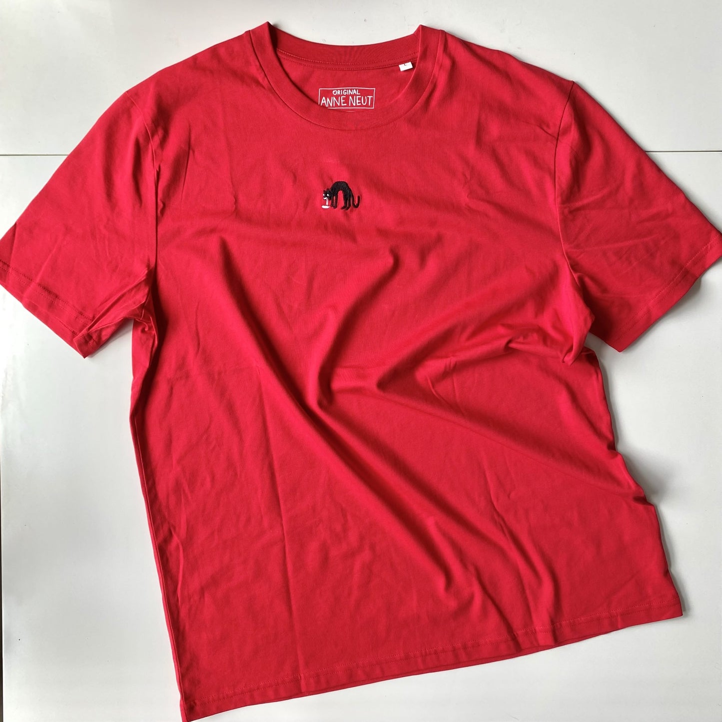 Shirt met borduurwerk van tekening van kotsende kat door Anne Neuteboom cabaretier in Anne Neut Boetiek