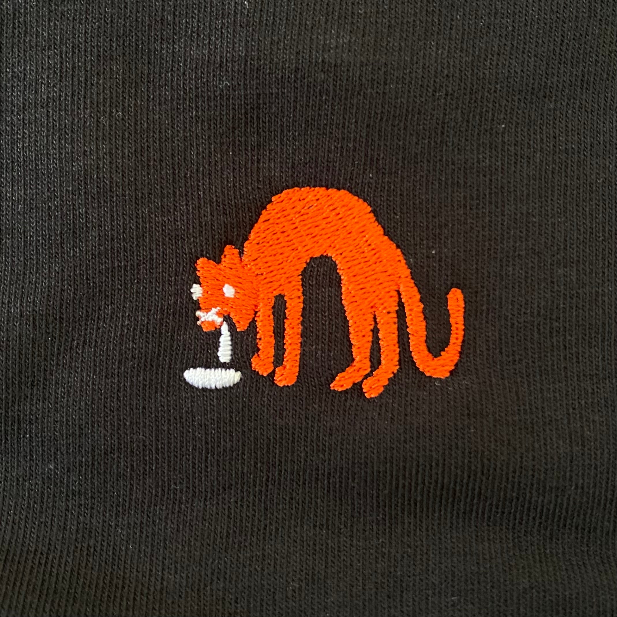 Sweater met borduurwerk van tekening van kotsende kat door Anne Neuteboom cabaretier in Anne Neut Boetiek