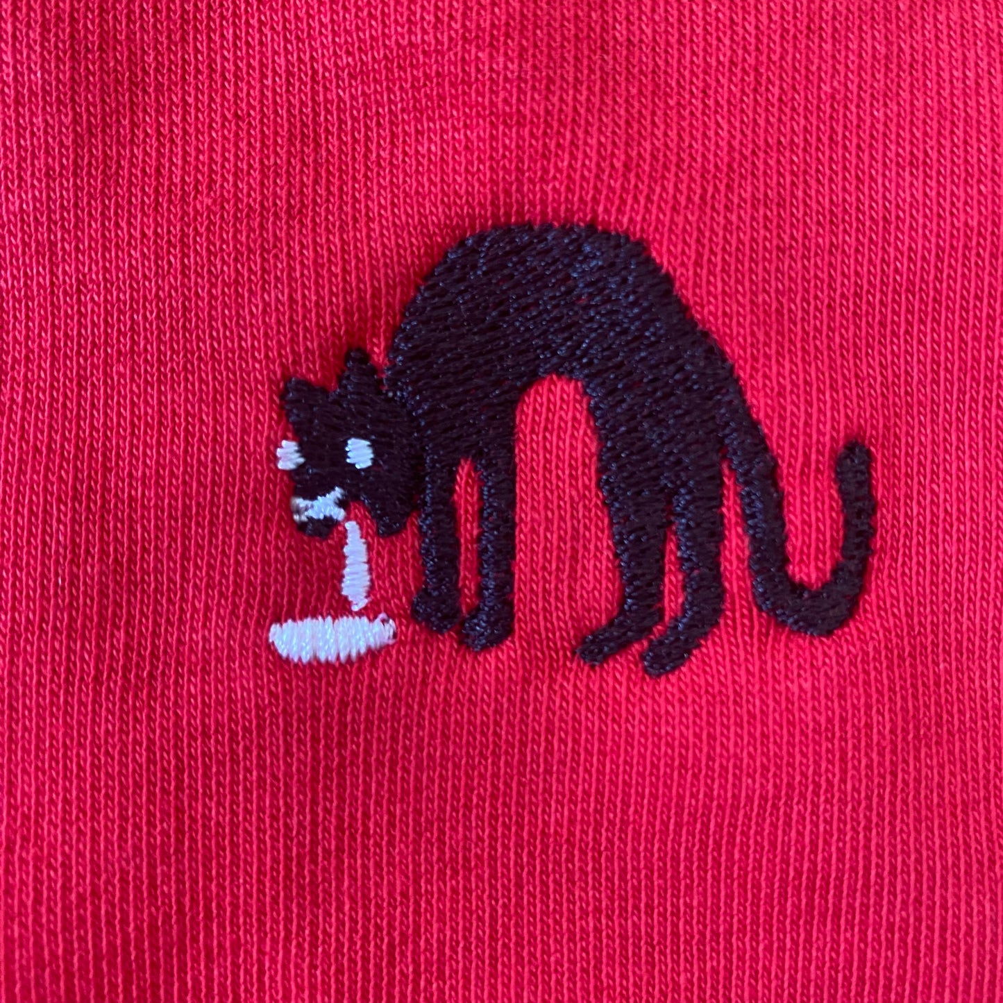 Sweater met borduurwerk van tekening van kotsende kat door Anne Neuteboom cabaretier in Anne Neut Boetiek