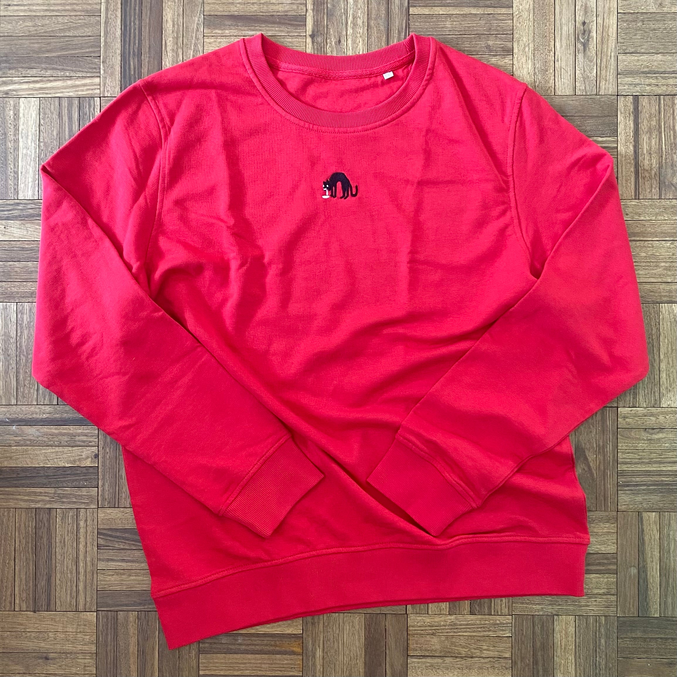 Sweater met borduurwerk van tekening van kotsende kat door Anne Neuteboom cabaretier in Anne Neut Boetiek