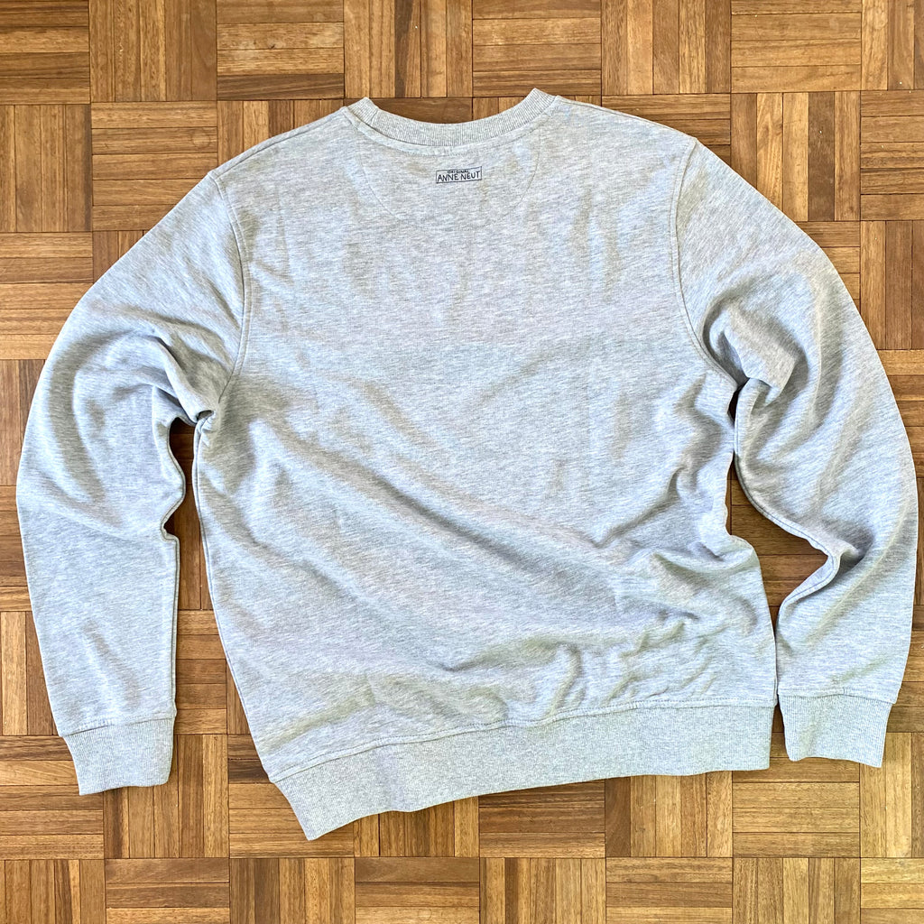 Sweater met borduurwerk van tekening van poepende hond door Anne Neuteboom cabaretier in Anne Neut Boetiek