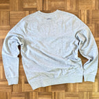 Sweater met borduurwerk van tekening van poepende hond door Anne Neuteboom cabaretier in Anne Neut Boetiek