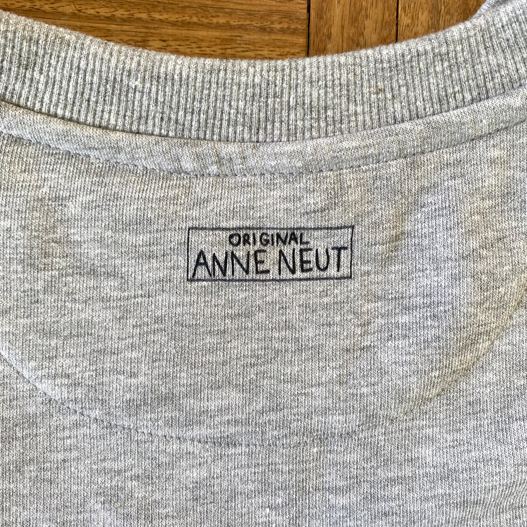 Sweater met borduurwerk van tekening van poepende hond door Anne Neuteboom cabaretier in Anne Neut Boetiek