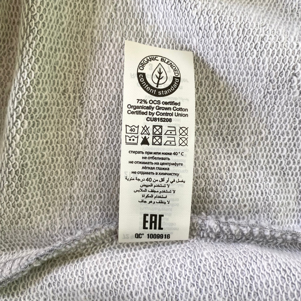 Sweater met borduurwerk van tekening van poepende hond door Anne Neuteboom cabaretier in Anne Neut Boetiek